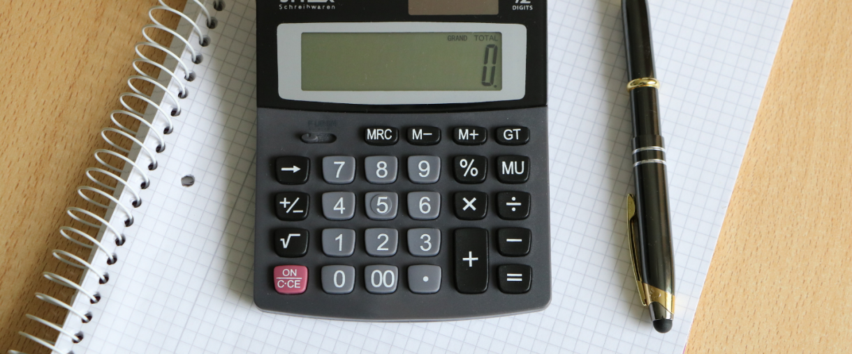 Calculator, pen, and graph paper on desk