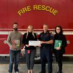 Group photo in front of fire truck for funding announcement